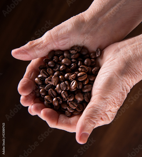 Old woman hands holding coffee beans