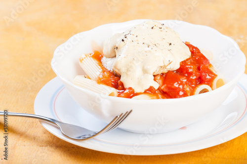 tomato pasta with rosmary cream chicken on top photo