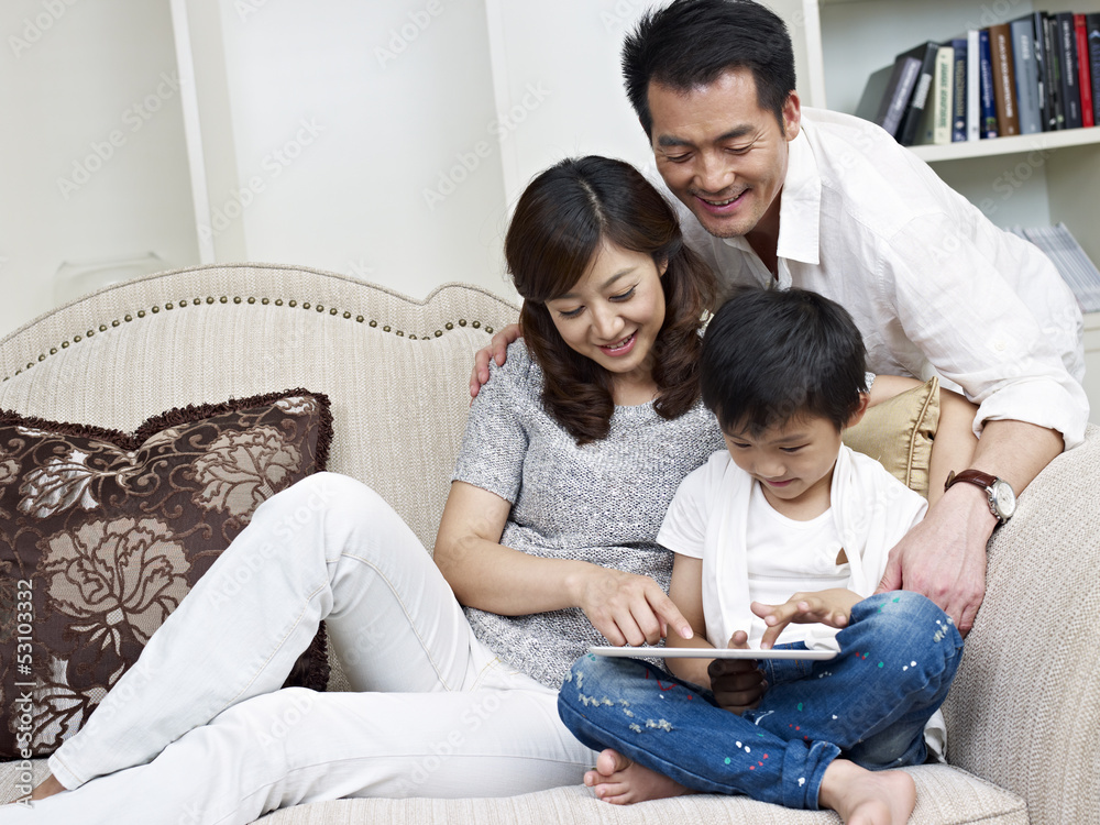 asian family using tablet computer at home asian family using tablet computer at home