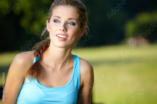  slim fitness brunette posing outdoors in nature.