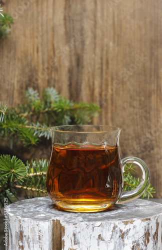 Glass of hot tea among christmas decorations