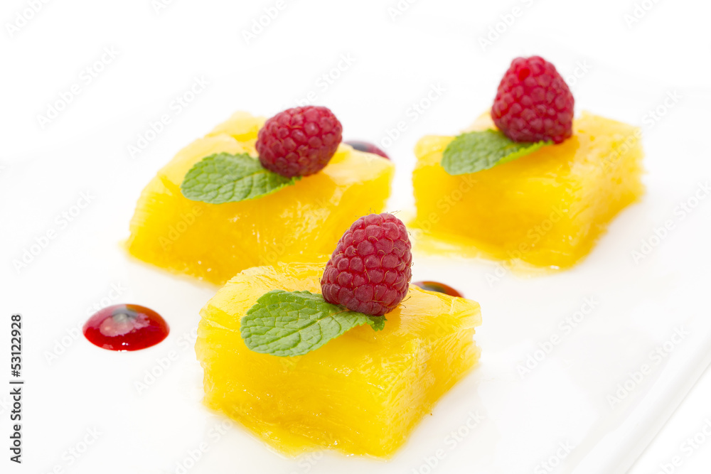 Dessert of pineapple and decorated with raspberries on a white background Dessert of pineapple and decorated with raspberries on a white background