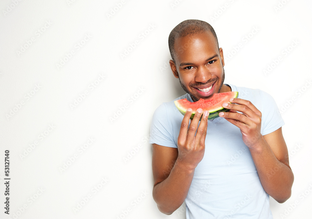 Handsome young man smiling and eating fresh watermelon Handsome young man smiling and eating fresh watermelon