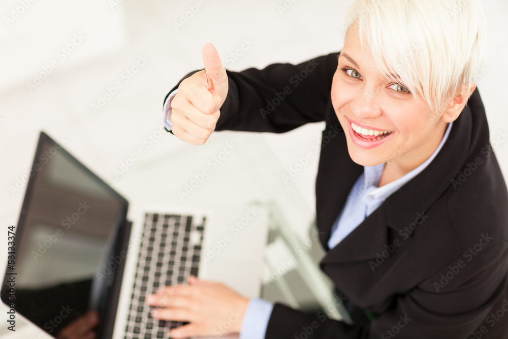 Businesswoman making positive thumb gesture Businesswoman making positive thumb gesture
