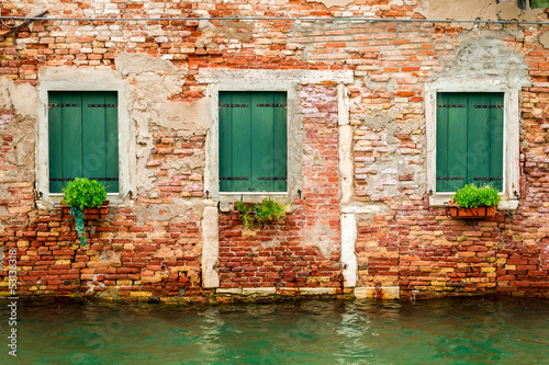 Three windows in ruined house on a canal in Venice © shaiith