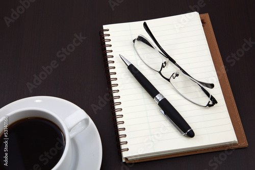 notebook with coffee cup on table