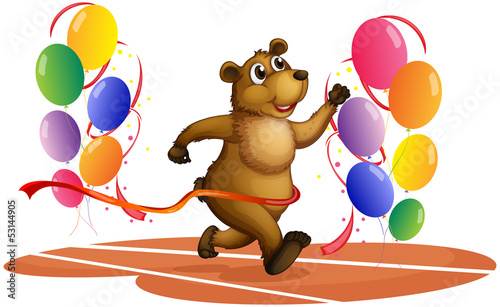 A bear running in the middle of colorful balloons