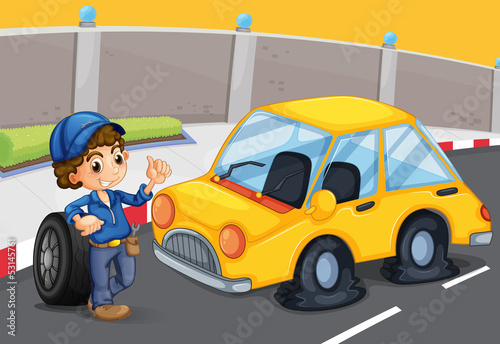 A boy standing in front of a car with a flat tire