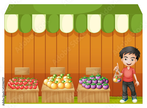 A fruit shop with a young boy wearing a red shirt
