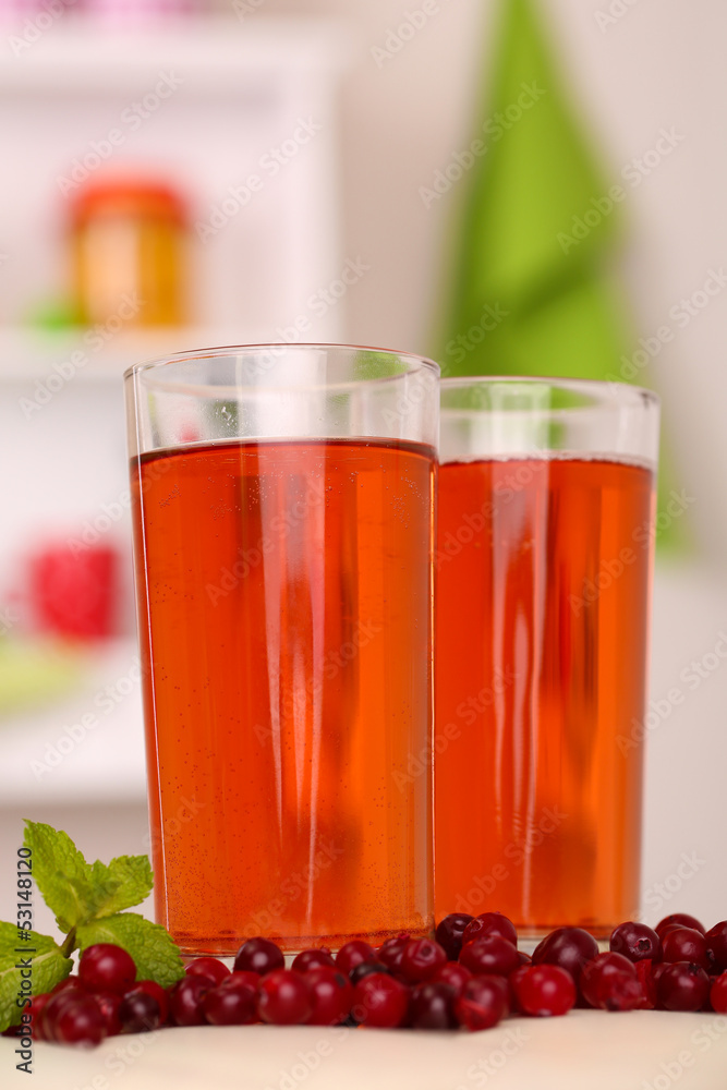 Glasses of cranberry juice and ripe red cranberries on table Glasses of cranberry juice and ripe red cranberries on table