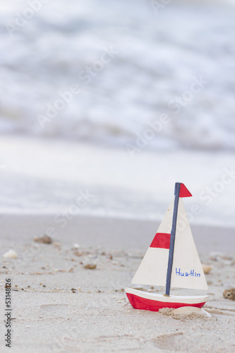 wood boat, red wooden sail boat written huahin on sand beach