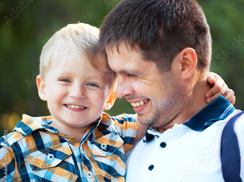 Happy father and his baby son having fun in the park