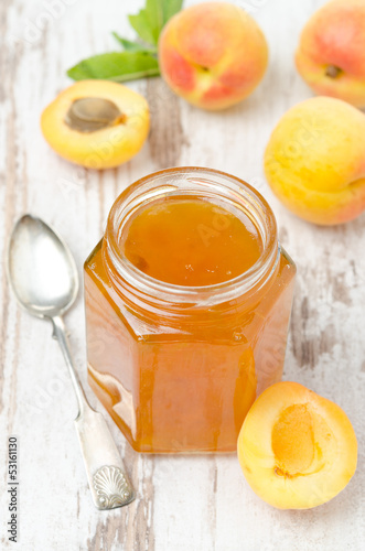 apricot confiture in a glass jar and fresh apricots, top view