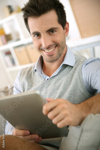 Smiling man websurfing on internet with tablet