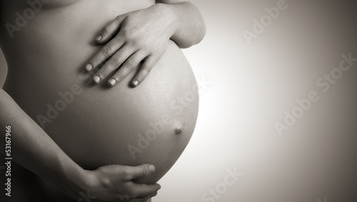 Fotografia belly of pregnant woman  monochrome on dark background