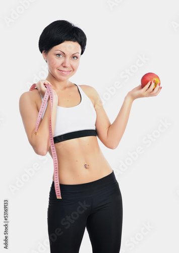 Portrait of young fitness woman with apple