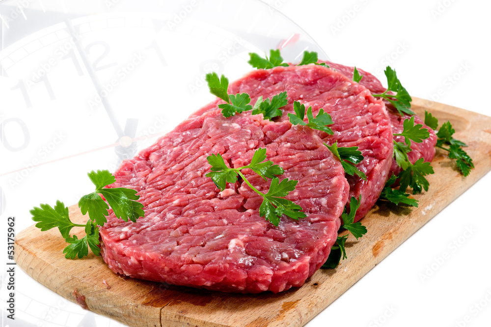 Hamburger of beef on wooden board with parsley Hamburger of beef on wooden board with parsley