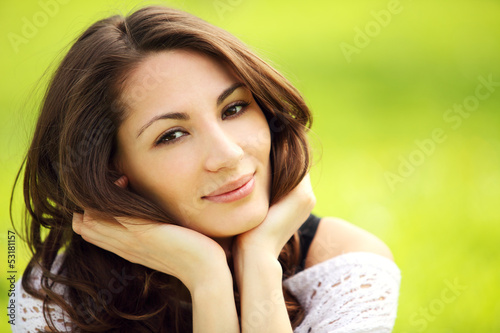 Image of young beautiful woman in summer park smiling