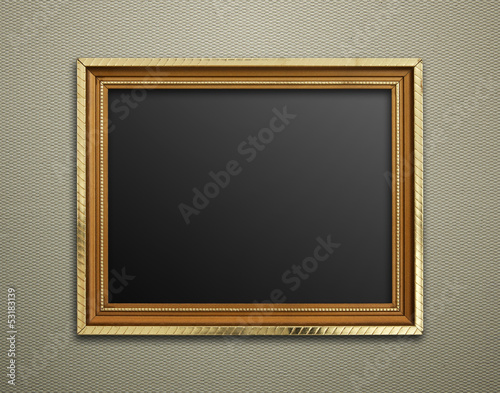 Empty golden vintage frame on wallpaper background © aopsan