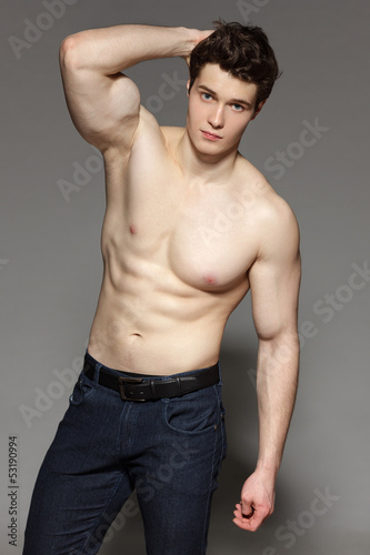 Sexy young man with bare torso with hand on his head