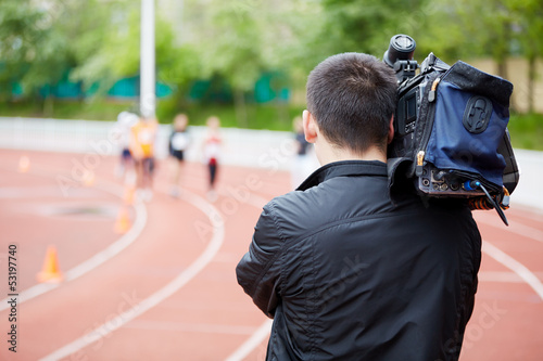 Cameraman shoots running races, view from back photo