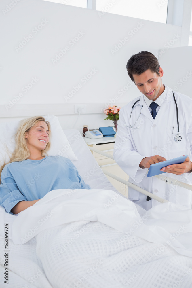 Fototapeta premium Smiling doctor showing digital tablet