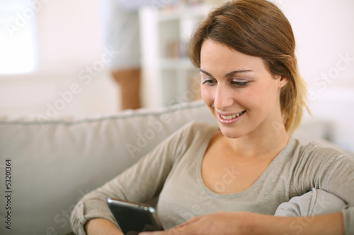 Young girl at home sending message with smartphone