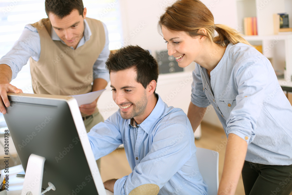 Workteam in office working on desktop computer