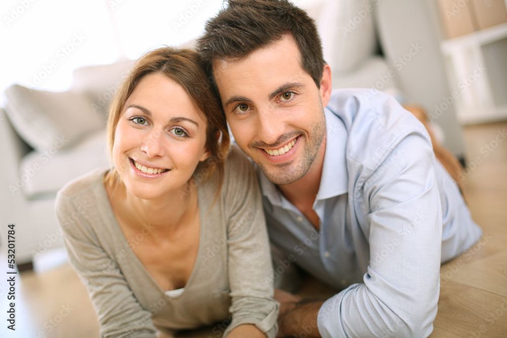 Cheerful couple laying on the floor at home Cheerful couple laying on the floor at home