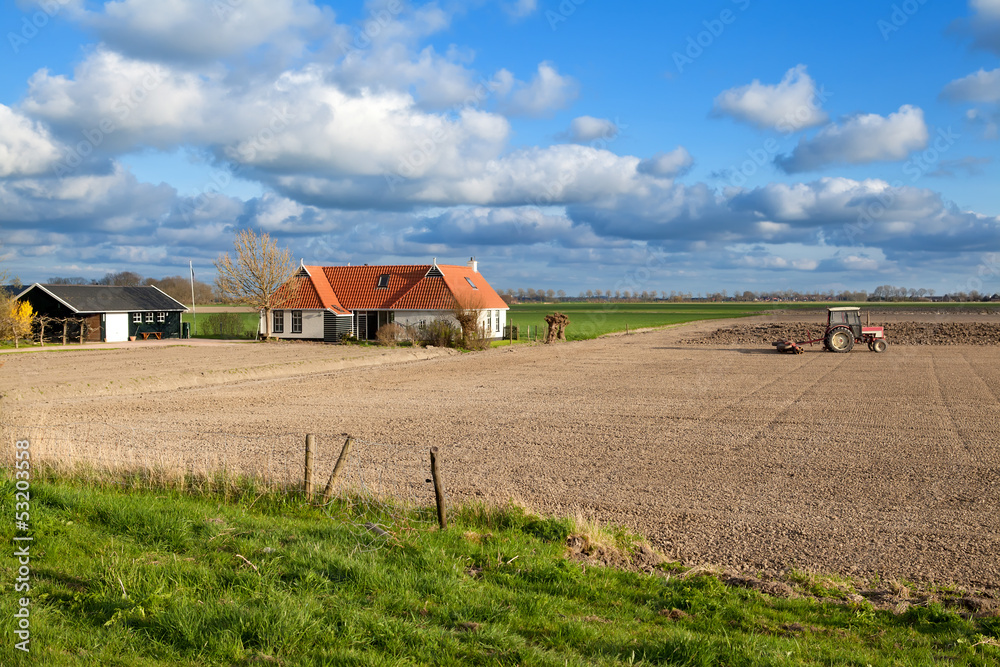 tractor plowing field by farmhouse tractor plowing field by farmhouse