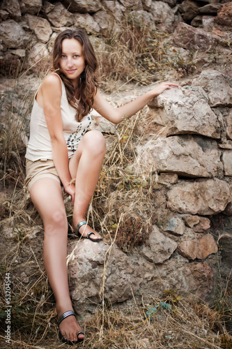 beautiful girl posing on a stone wall background