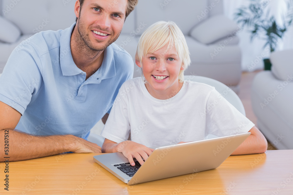 Smiling father and his son using laptop Smiling father and his son using laptop