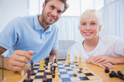 Father and his little boy playing chess