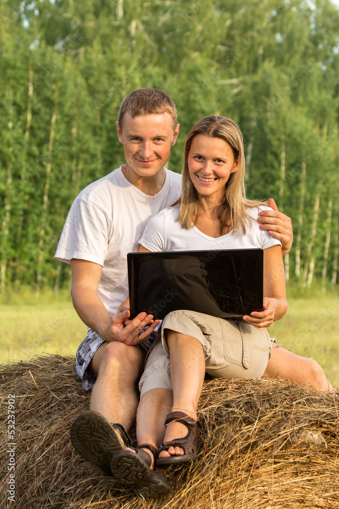 Beautiful two people on haystack look the Internet Beautiful two people on haystack look the Internet