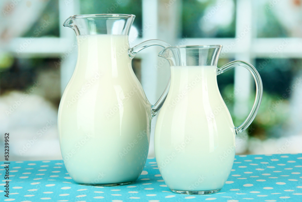 Pitchers of milk on table in room Pitchers of milk on table in room