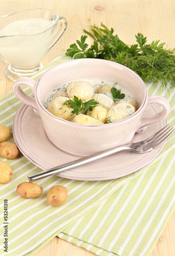 Tender young potatoes with sour cream and herbs in pan Tender young potatoes with sour cream and herbs in pan