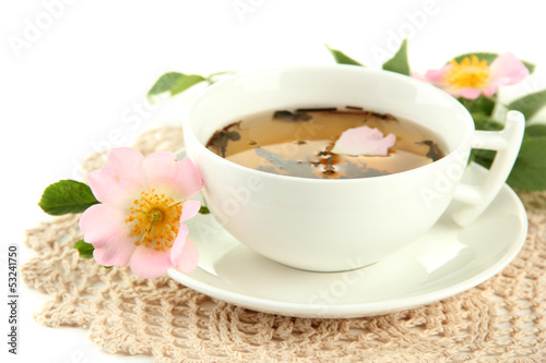 Cup of herbal tea with hip rose flowers, isolated on white