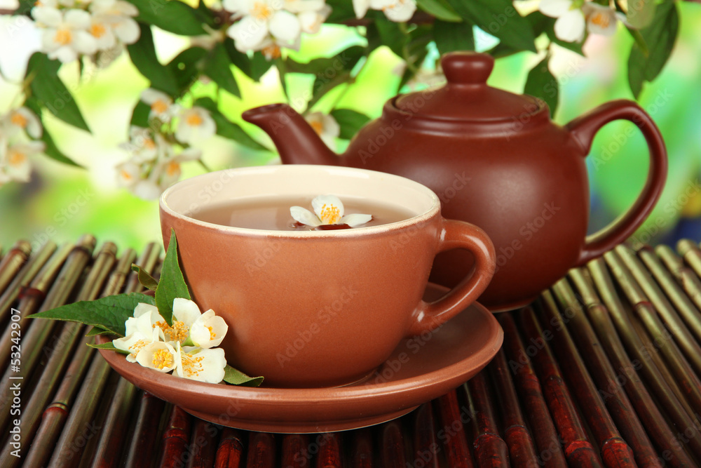 Cup of tea with jasmine, on bamboo mat, on bright background Cup of tea with jasmine, on bamboo mat, on bright background