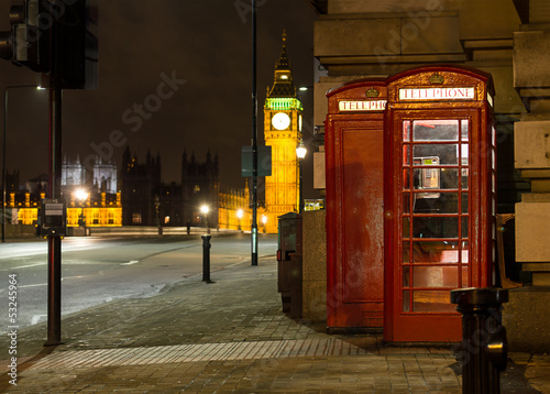 Traditional red phone booth in London with the Big Ben in the ba