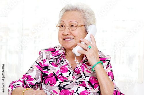 Asian senior woman in her 70s talking on the phone