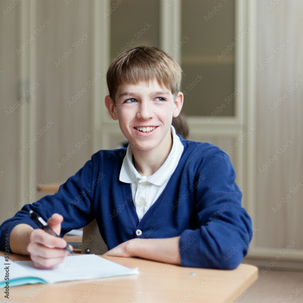 Diligent student sitting at desk, classroom Diligent student sitting at desk, classroom