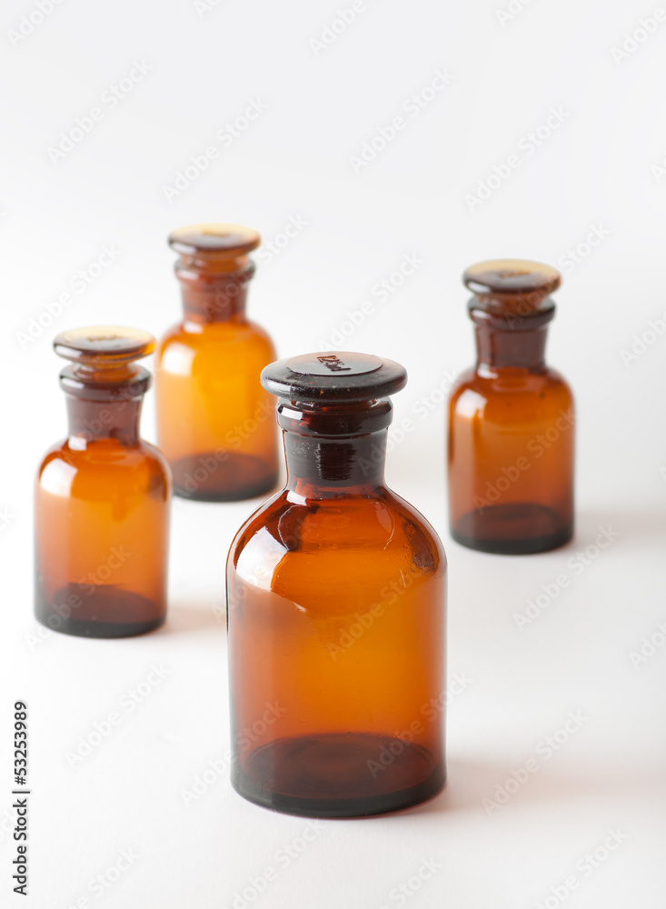 Small chemical glass bottles on white background