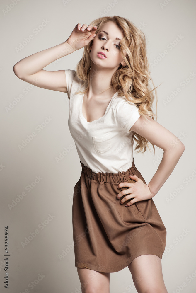 Posing blond woman with long curly hair on white Posing blond woman with long curly hair on white