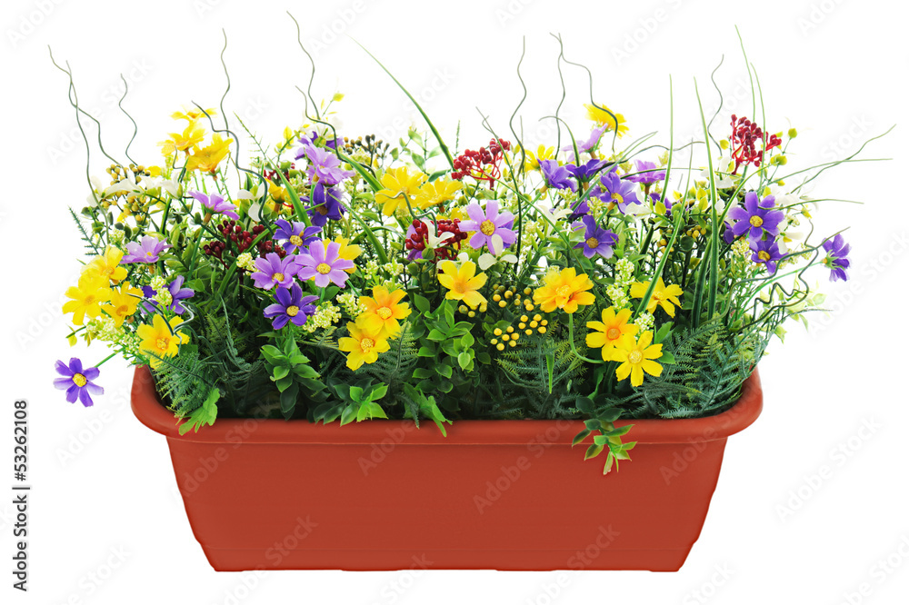 Composition of artificial garden flowers in brown flowerpot isol