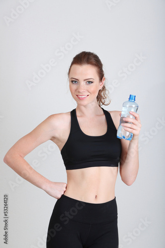 Beautiful young woman with bottle of water