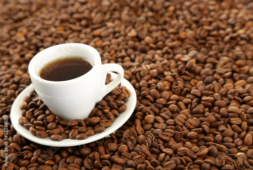 Cup of coffee on coffee beans background