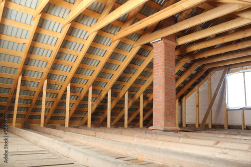 Roof frame covered by profiled metal sheet and brick chimney