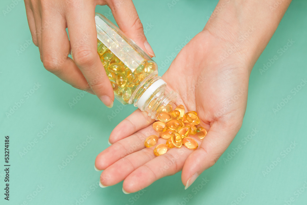 woman 's hand take vitamin Omega-3 fish oil pills woman 's hand take vitamin Omega-3 fish oil pills