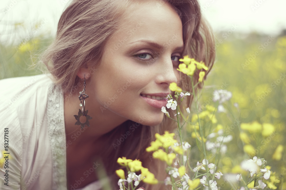 Portrait of a sexy blonde inhales the scent of flowers Portrait of a sexy blonde inhales the scent of flowers