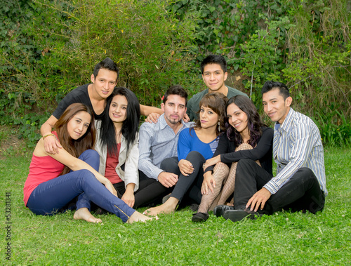 Happy group of students sitting at the park